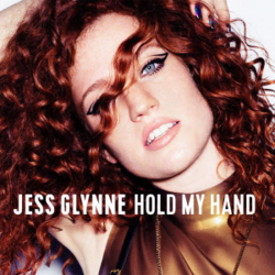 Album cover featuring Jess Glynne - a woman with bright curly red hair poses with her arms raised, wearing gold clothing and bold eyeliner. White text across the image reads, 